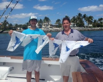 Men holding up Blue marlin flags